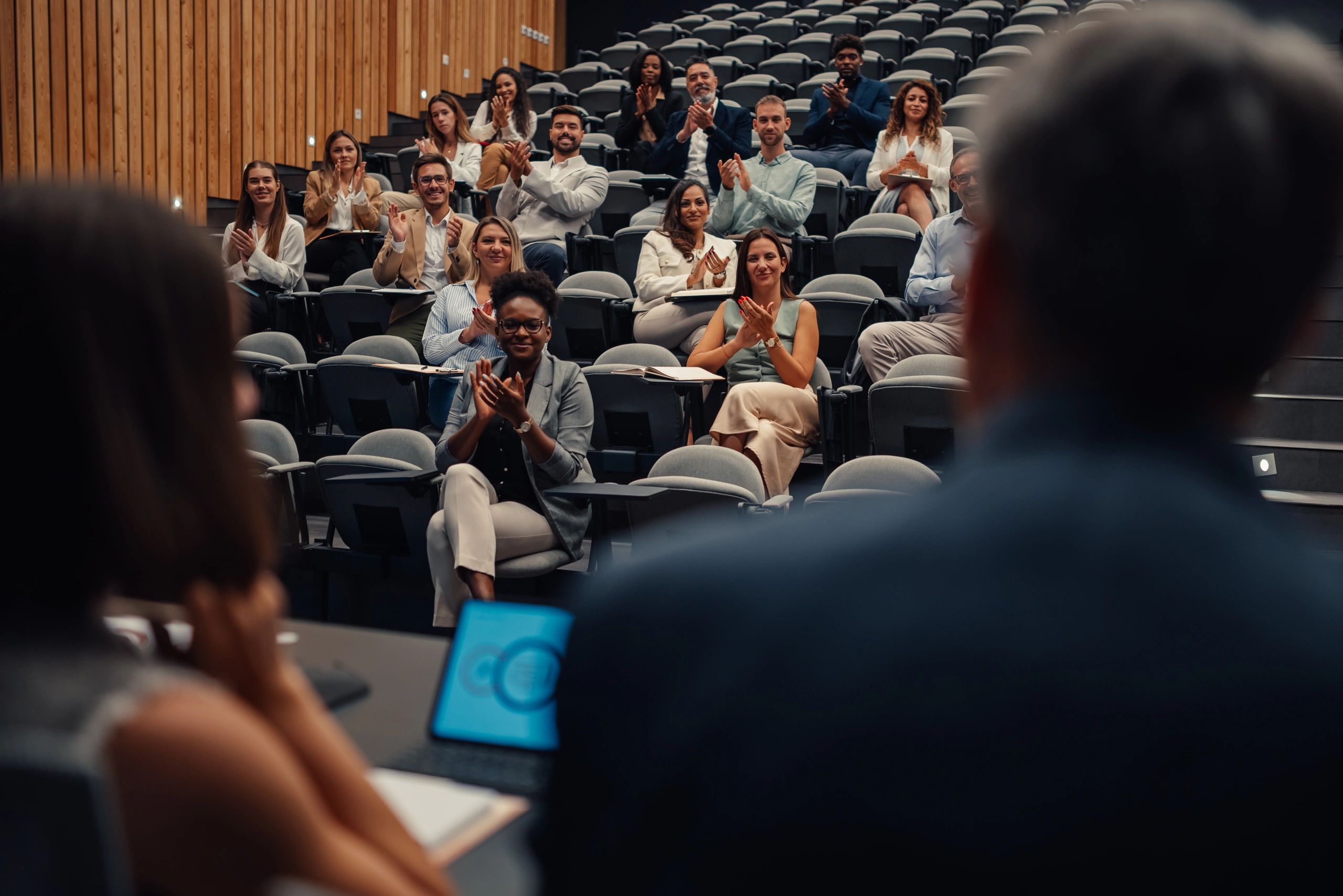 Business people applauding presentation at diversity conference
